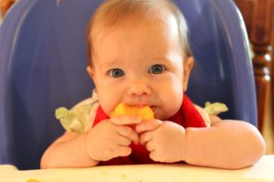 Ребенок ест апельсин