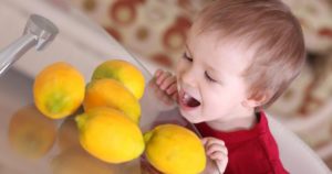 Ребенок смотрит на лимоны