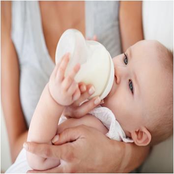 ребенок пьет козье молоко с бутылочки