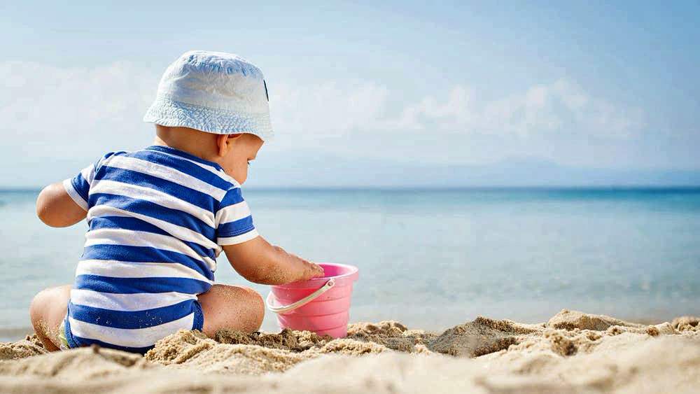Ребенок играет на пляже в игрушки